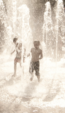 children run through fountain